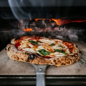 Delicious wood-fired pizza baking in a traditional oven in London.