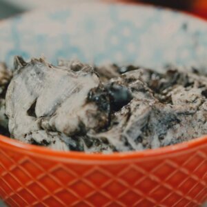 Delicious cookies and cream ice cream in a vibrant red bowl, tempting dessert treat.