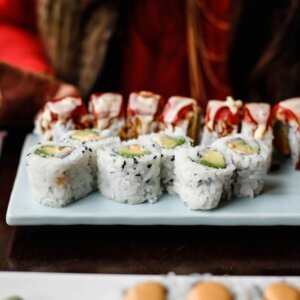 Tasty sushi rolls on a ceramic plate, showcasing Japanese cuisine in an intimate indoor dining setting.